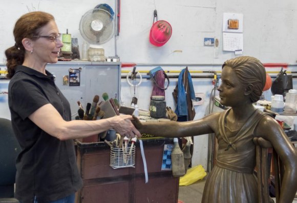 RIOC Steps Up To Give FDR Hope Memorial A Major Boost Toward Completion Sculptor Meredith Bergmann takes FDR's place in practice, shaking the young girl's hand.