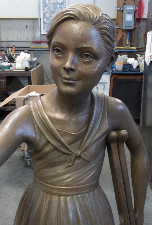 RIOC Steps Up To Give FDR Hope Memorial A Major Boost Toward Completion The girl tucks both of her crutches under one arm, enabling her to accept FDR's expected hand with the other.