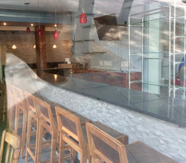 Nisi, Replacing Trellis, Set To Open September 1st Counter stools through reflections the glass in the late afternoon.