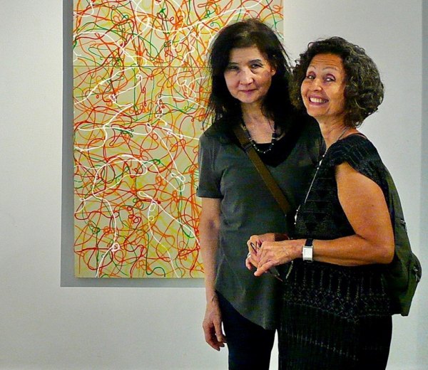 Seen at "Free Time," RIVAA Gallery Opening Toshiko Kitano Groner (L) with a painting by Ioan Popoiu.